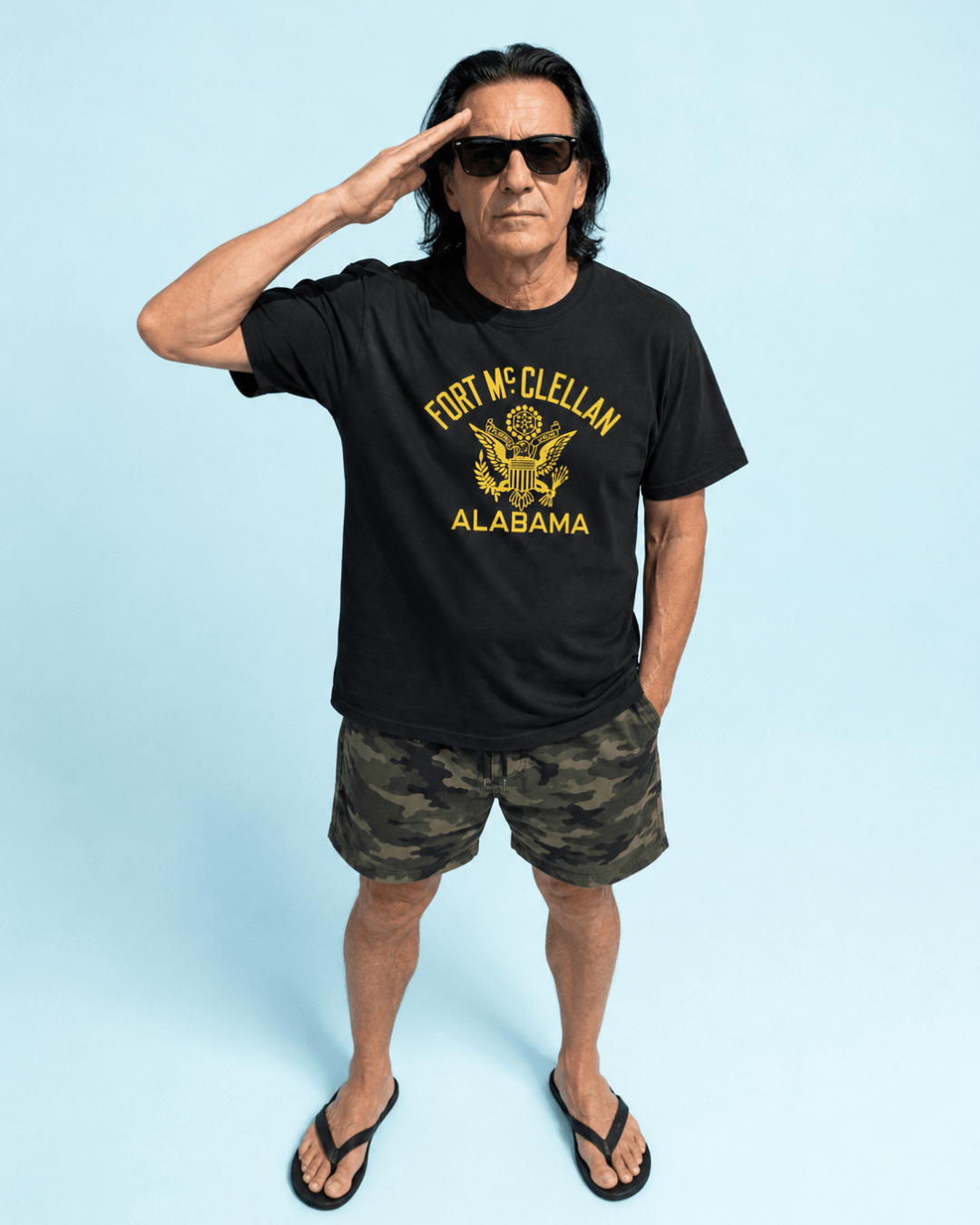 Man saluting in ALABAMA EAGLE BOOTLEG T-SHIRT | FORT McCLELLAN HERITAGE, showcasing American military history.
