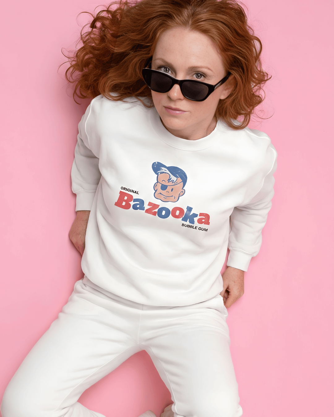 BAZOOKA JOE SWEATER | RETRO BUBBLEGUM CLUB worn by a model against a pink background, showcasing vintage pop culture.