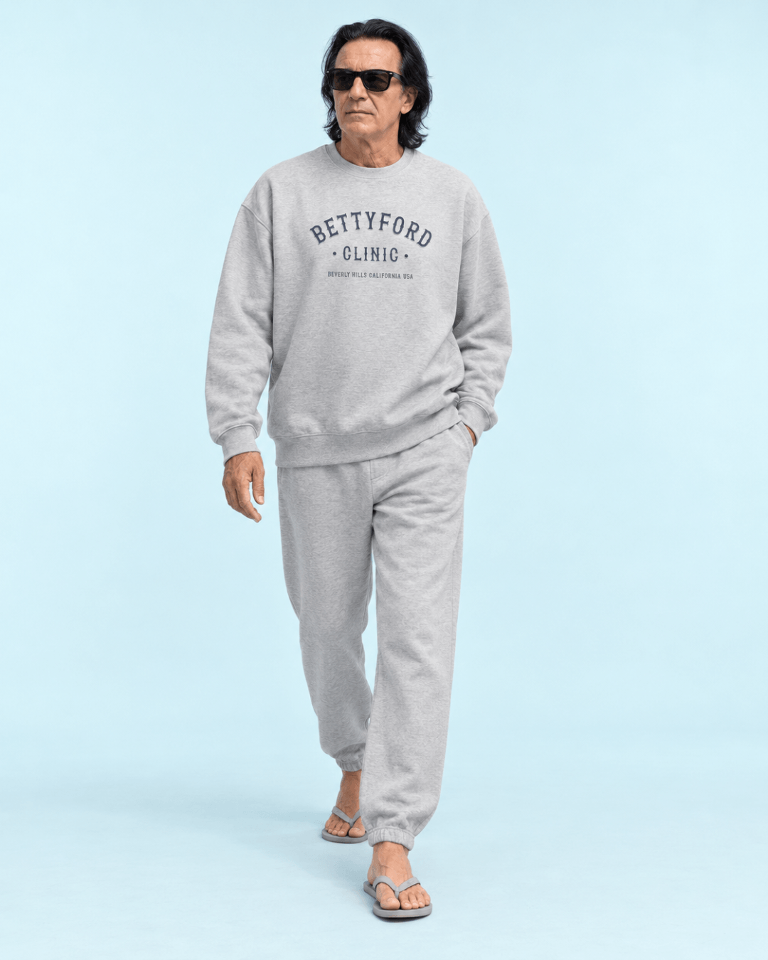 Man wearing a gray Betty Ford Clinic Heavy Sweater with relaxed fit and sunglasses.
