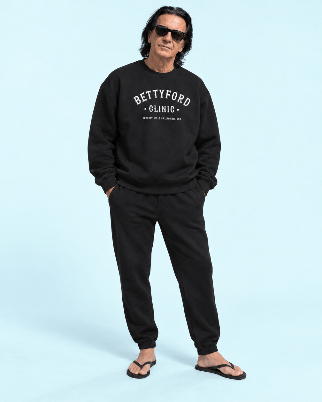 Man wearing a Betty Ford Clinic Heavy Sweater with a relaxed fit, sunglasses, and stylish black pants.