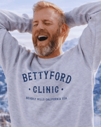 Man wearing a BETTY FORD CLINIC HEAVY SWEATER with a mountain backdrop.