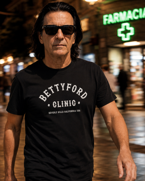 Person wearing a black Betty Ford Clinic T-Shirt | Varsity Team in an urban setting at night.