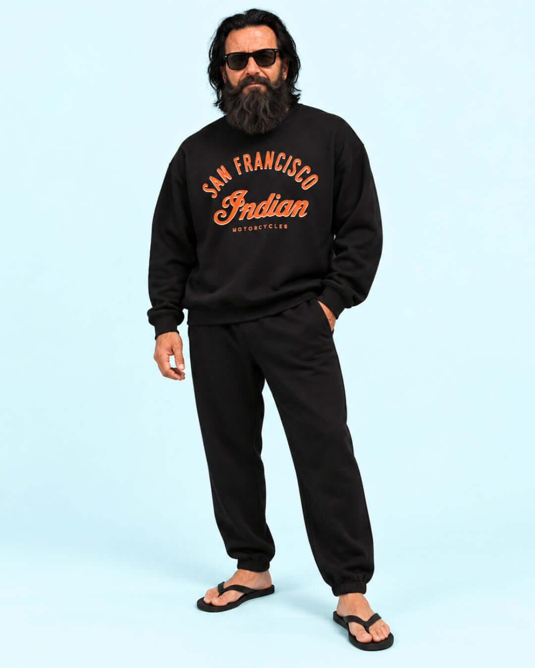 Walter wearing the Black Bay Area Motorcycle Heavy Sweater with matching joggers and flip-flops against the light blue BINKY studio background.