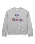 Front flat product image of the Bazooka Joe Club Heavy Sweater in Grey, showing an oversized crewneck sweatshirt with a distressed front print featuring Bazooka Joe’s face above bold red and blue Bazooka lettering, plus small black “ORIGINAL” and “BUBBLE 