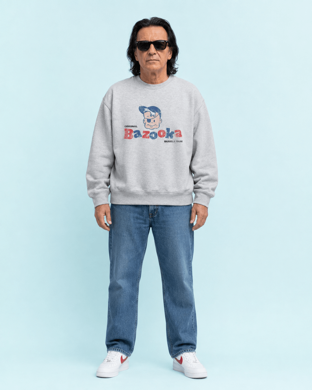 Bazooka Joe Club Heavy Sweater worn by a man, gray sweatshirt with Bazooka graphic on a light blue background.