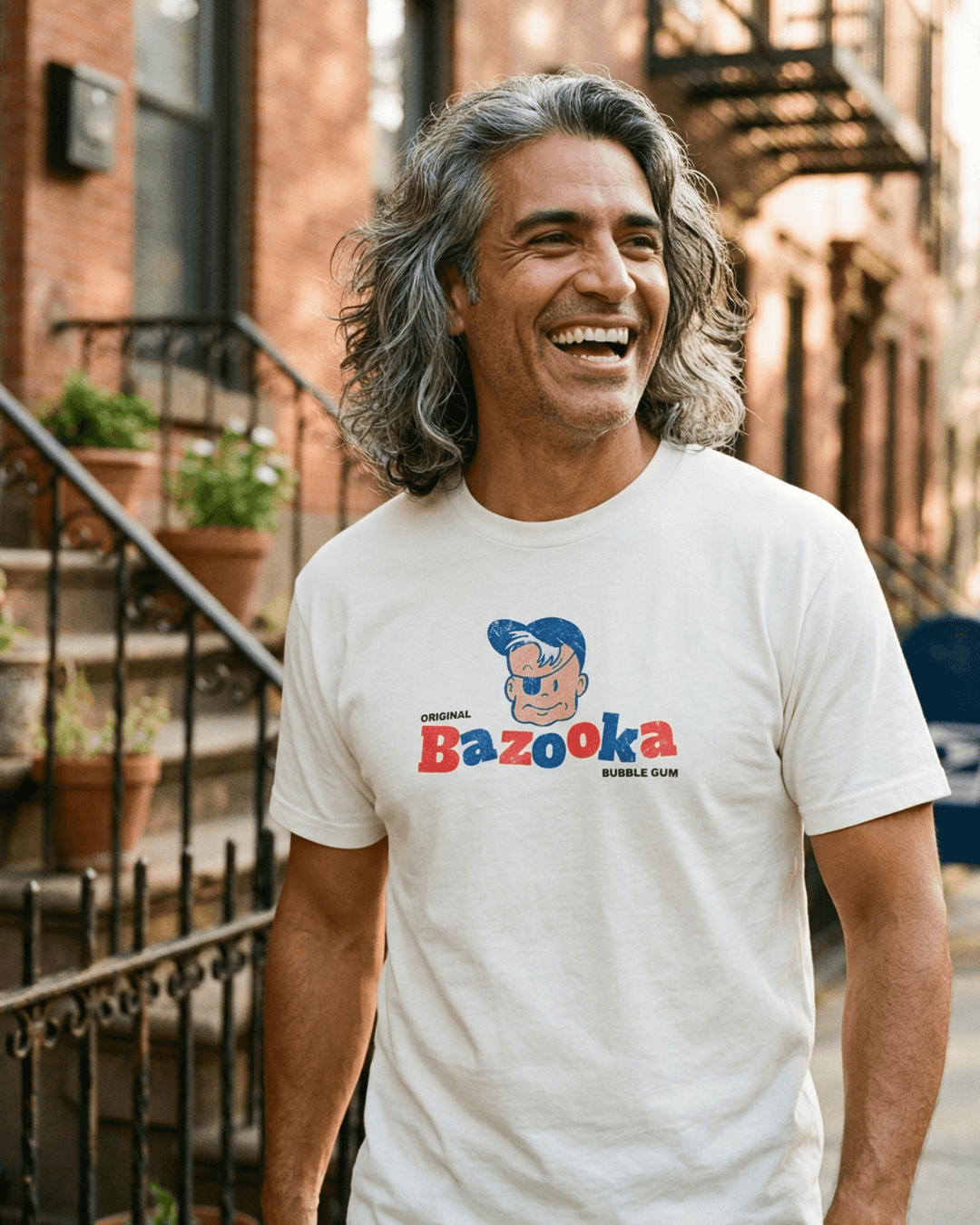 BAZOOKA JOE T-SHIRT | RETRO BUBBLEGUM LEGEND worn by a man smiling outdoors.