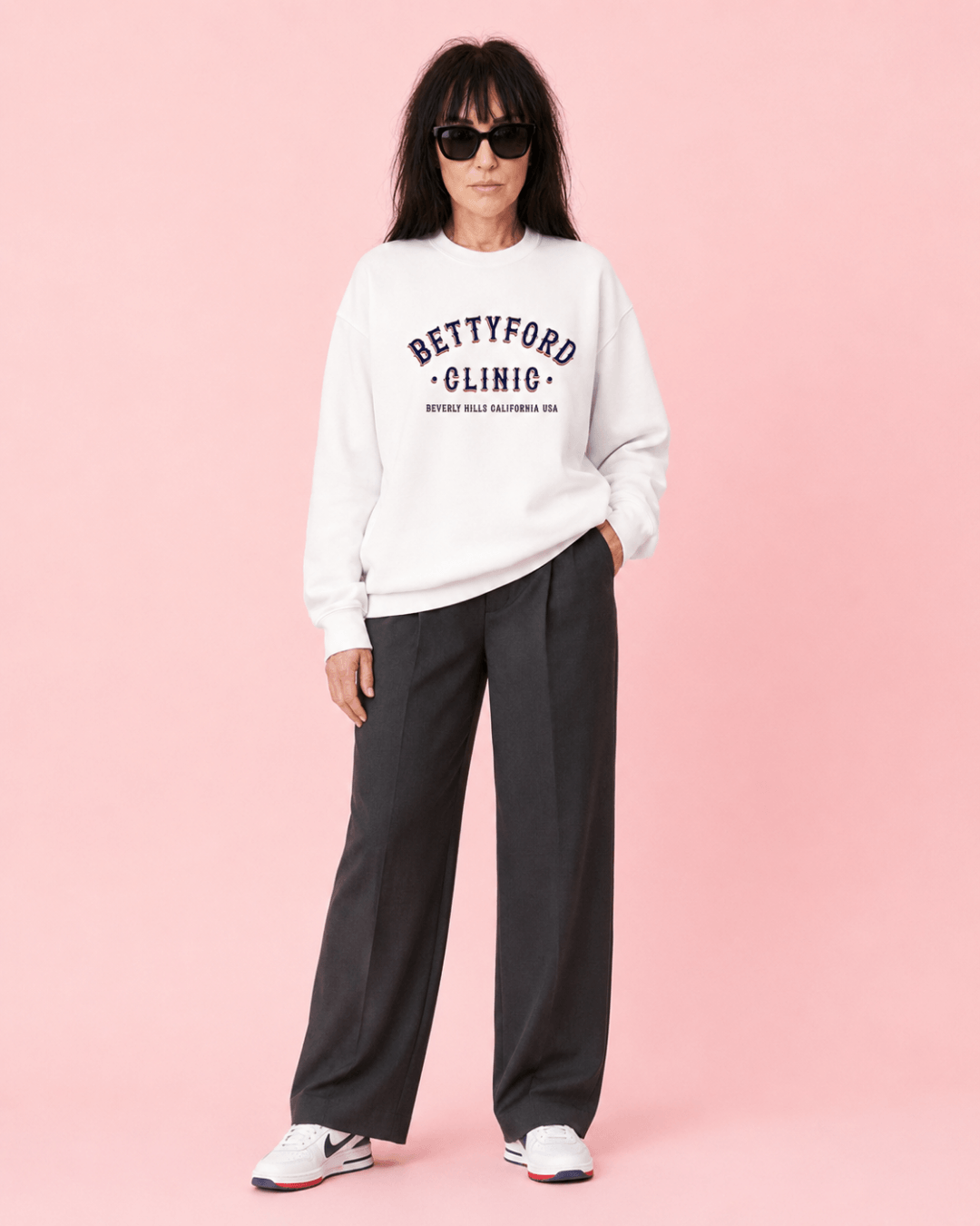 Betty Ford Clinic RWB Heavy Sweater worn by a model, showcasing stylish varsity culture on a pink background.