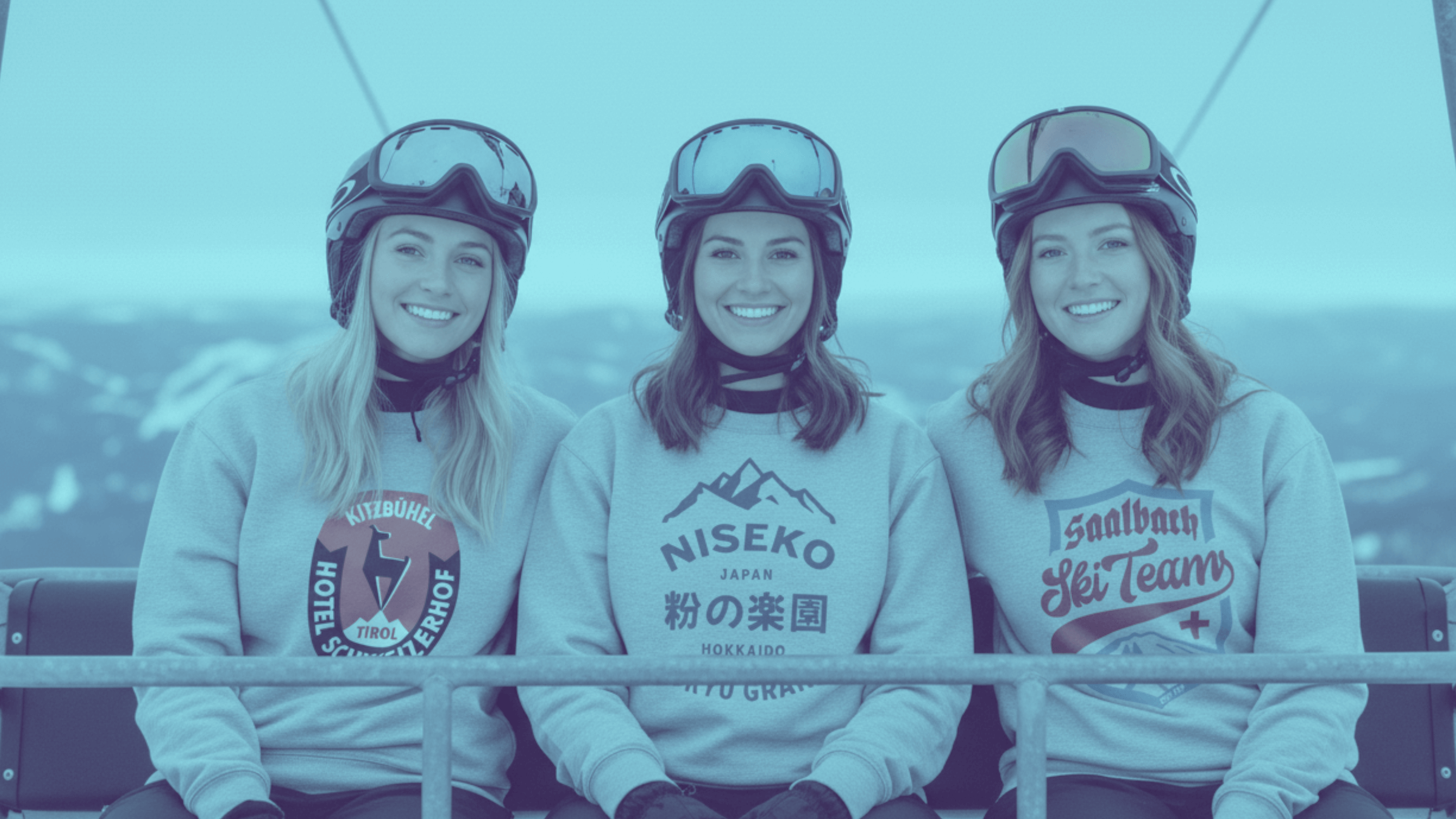 Three women in ski gear smiling on a chairlift, showcasing winter sports fashion in Niseko, Japan.