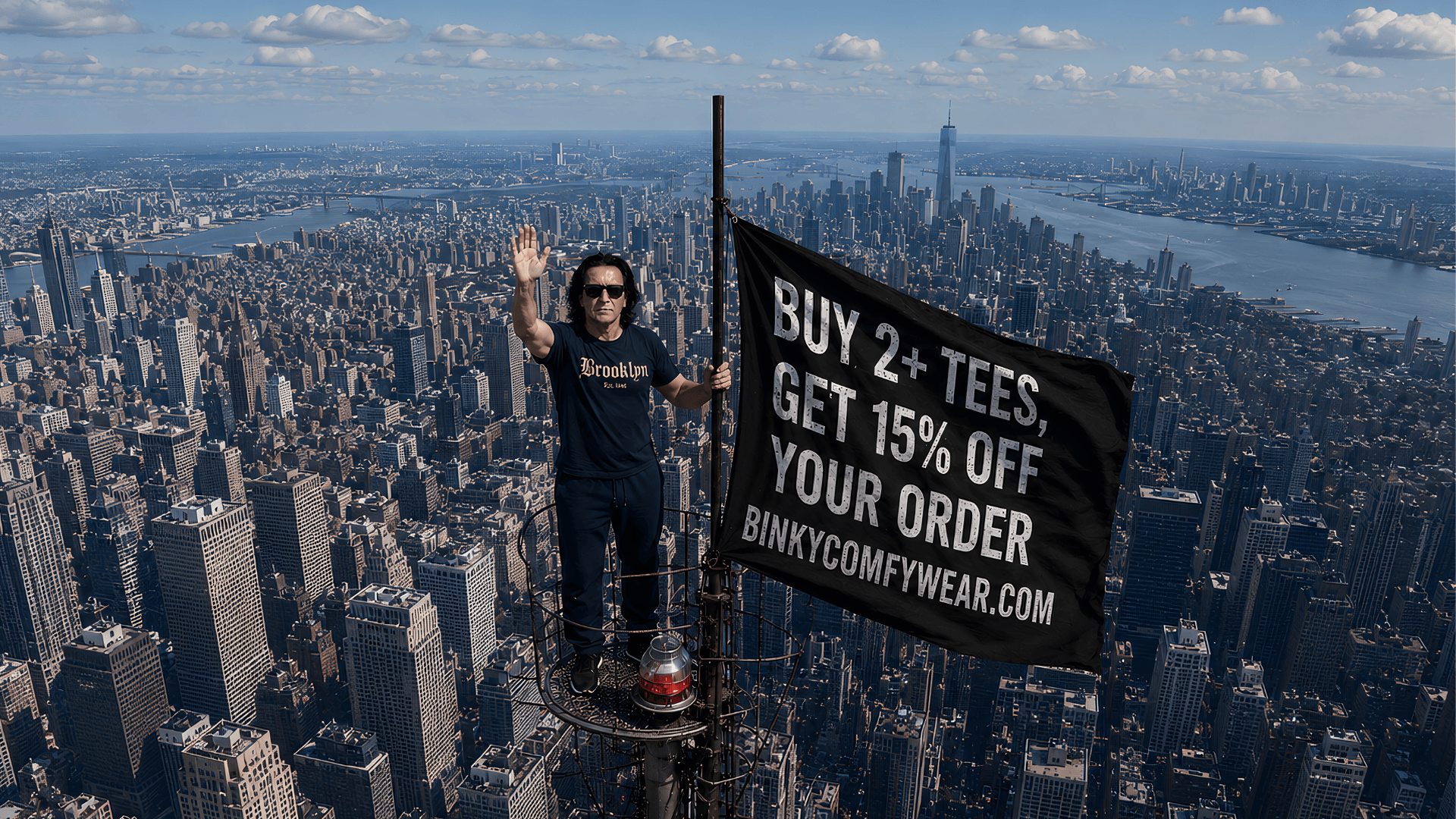Man standing on skyscraper holding a flag promoting a t-shirt sale with a city skyline in the background.