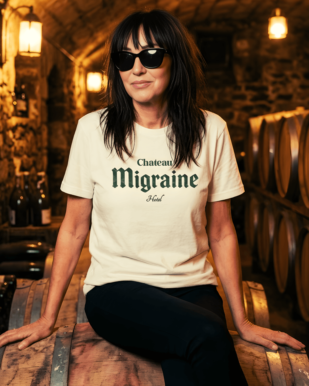 Chateau Migraine T-Shirt | Grand Cru Hangover worn by a woman in a winery setting with barrels.