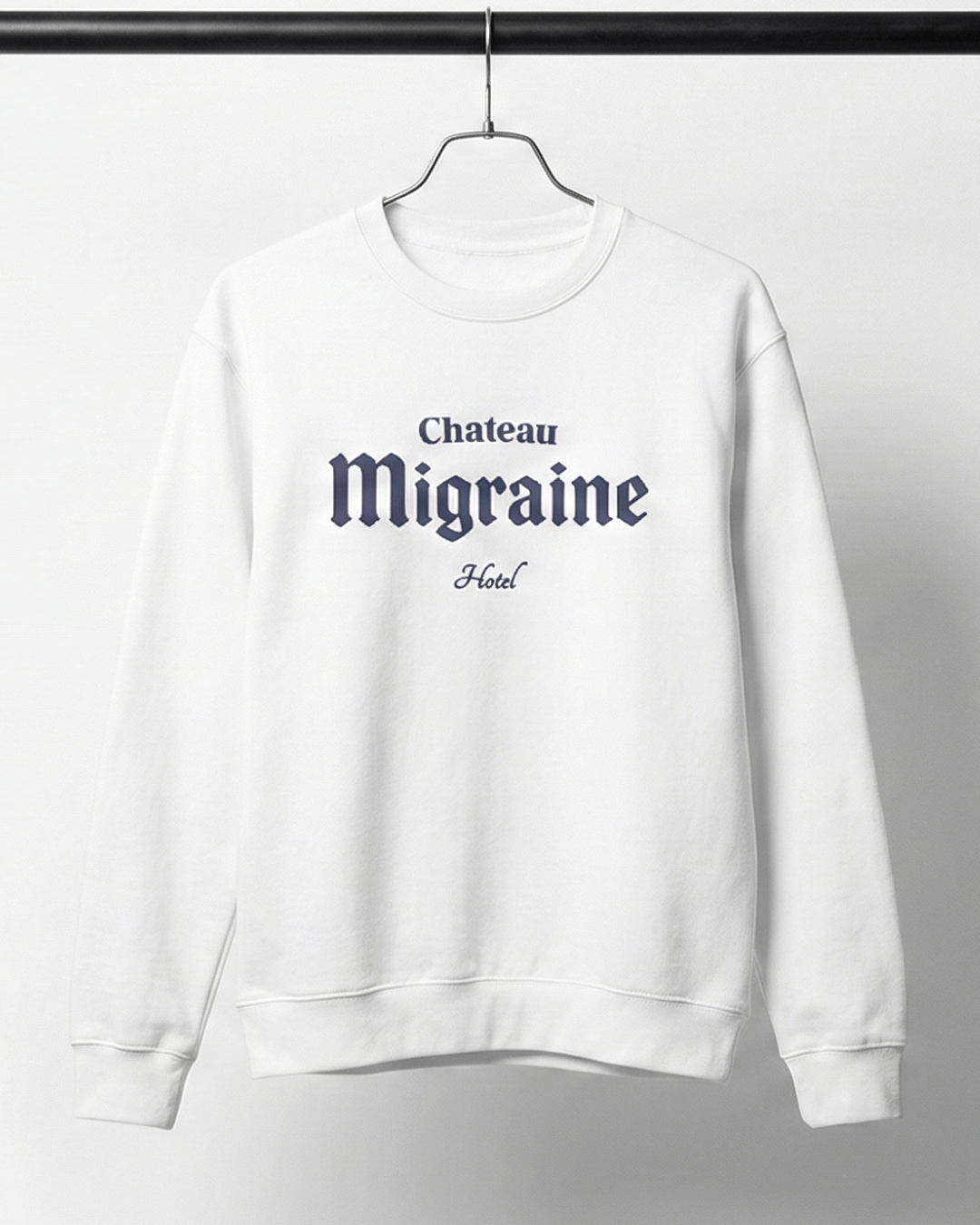 hotel migraine heavy sweater displaying Chateau Migraine logo on a white oversized sweatshirt.