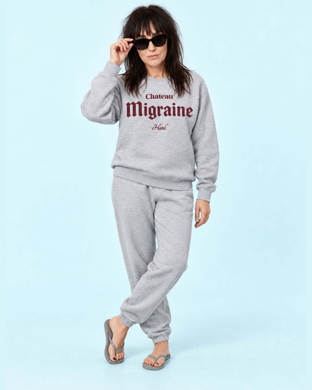 Helga wearing the Sport Grey Chateau Migraine Soft Sweater with mahogany print, grey joggers and light grey flip-flops.