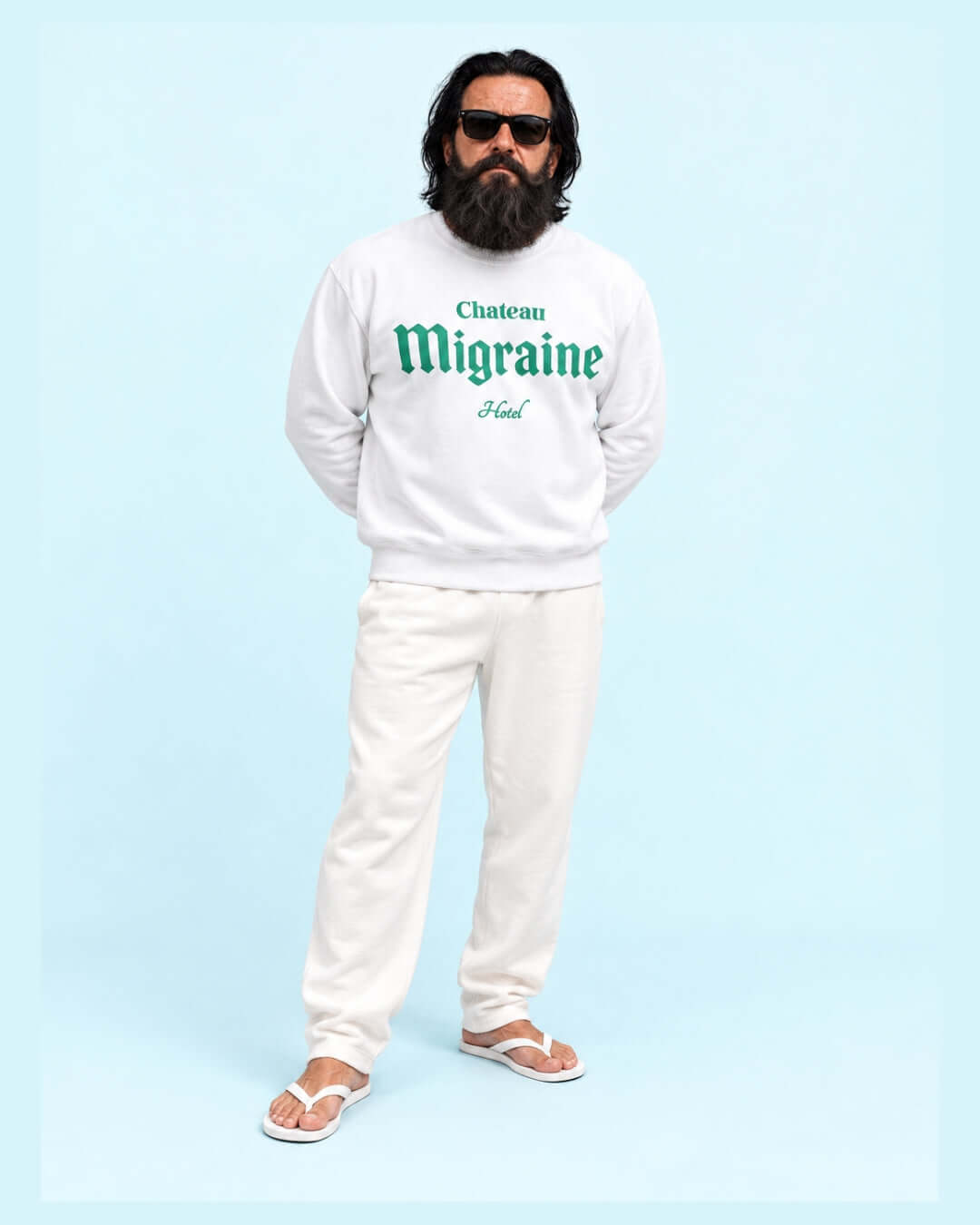 Walter wearing the White Chateau Migraine Soft Sweater with green print, white joggers and white flip-flops.