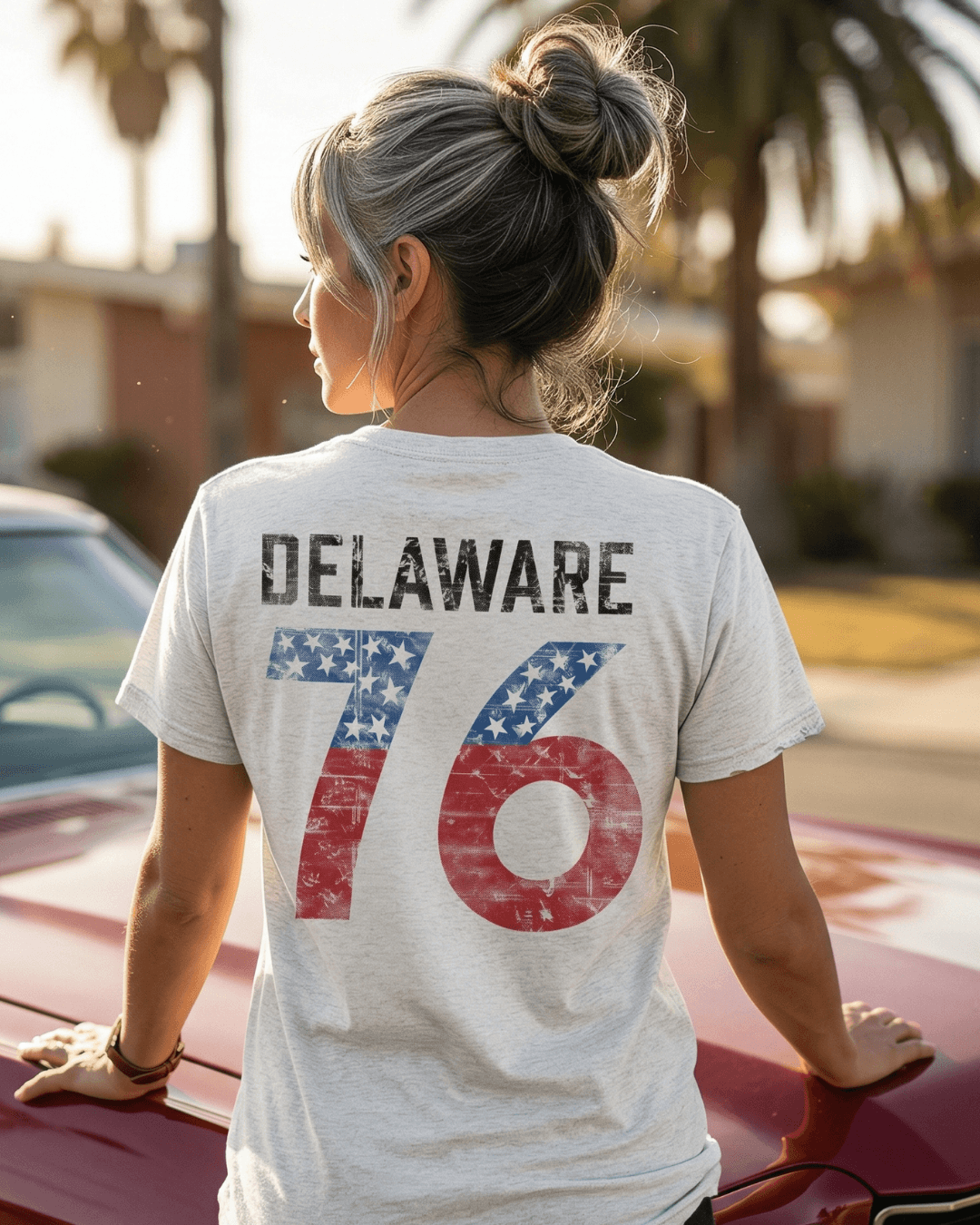 Model wearing Delaware '76 T-shirt featuring American flag design on the back, showcasing a vintage style.