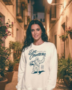 Model wearing DOS CERVEZAS IBIZA SWEATER in a charming Ibiza alley surrounded by flowers.