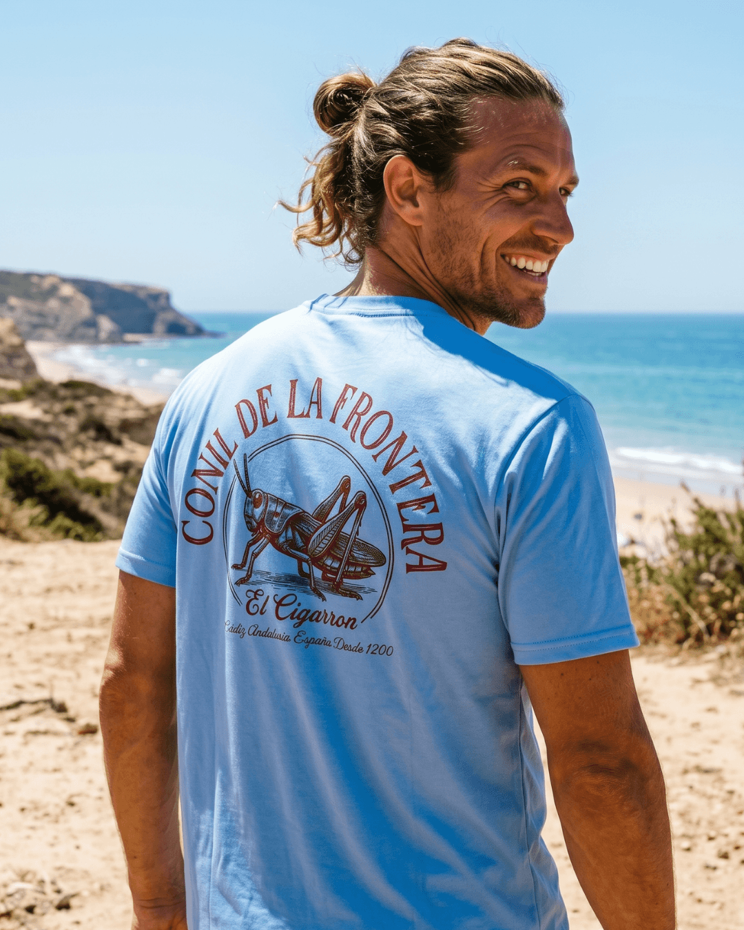Man wearing EL CIGARRON T-SHIRT | SUN, SALT & SPIRIT by the beach, showcasing a coastal vibe.