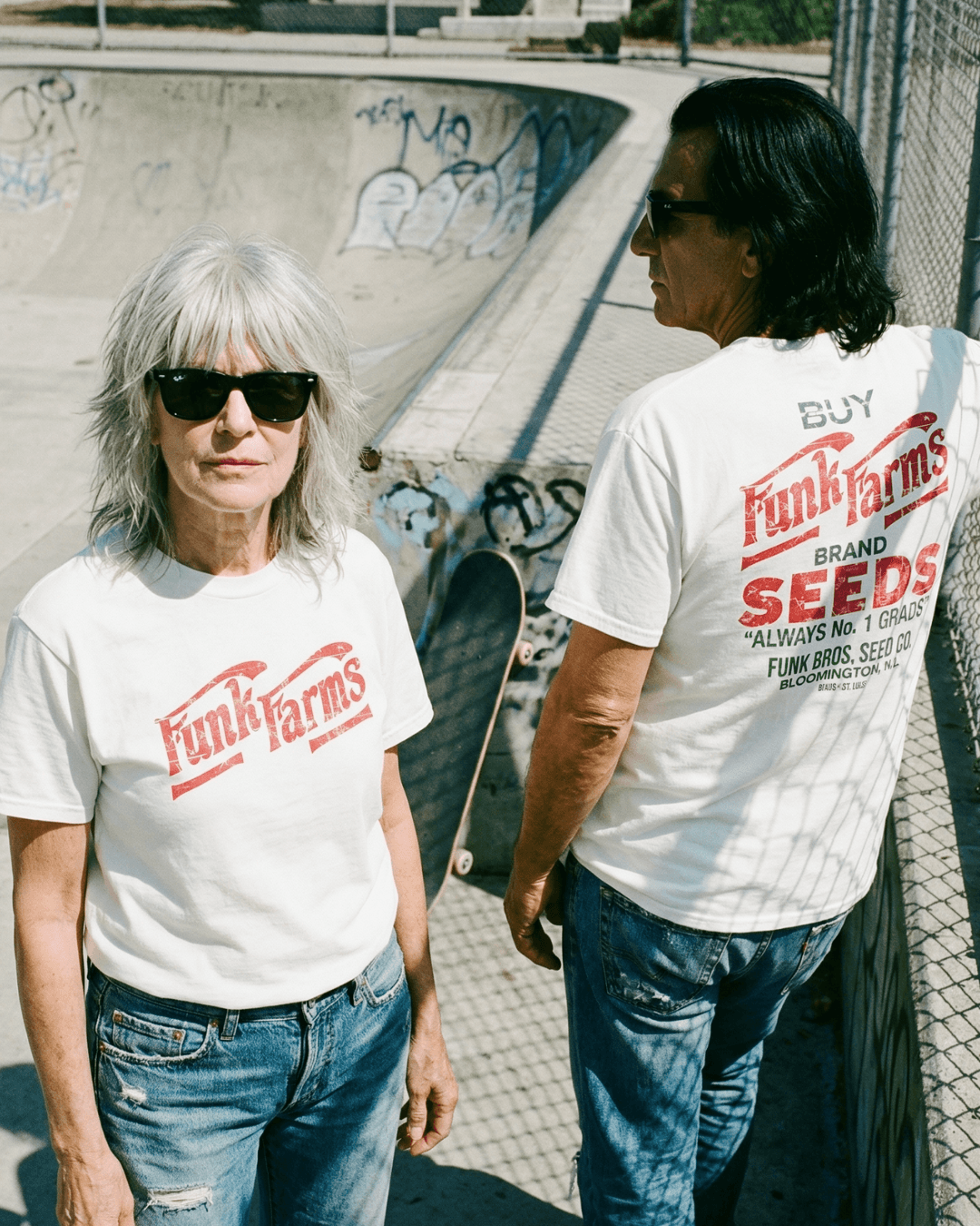 Two models wearing FUNK FARMS T-SHIRT in a skate park, showcasing its trendy design and relaxed fit.