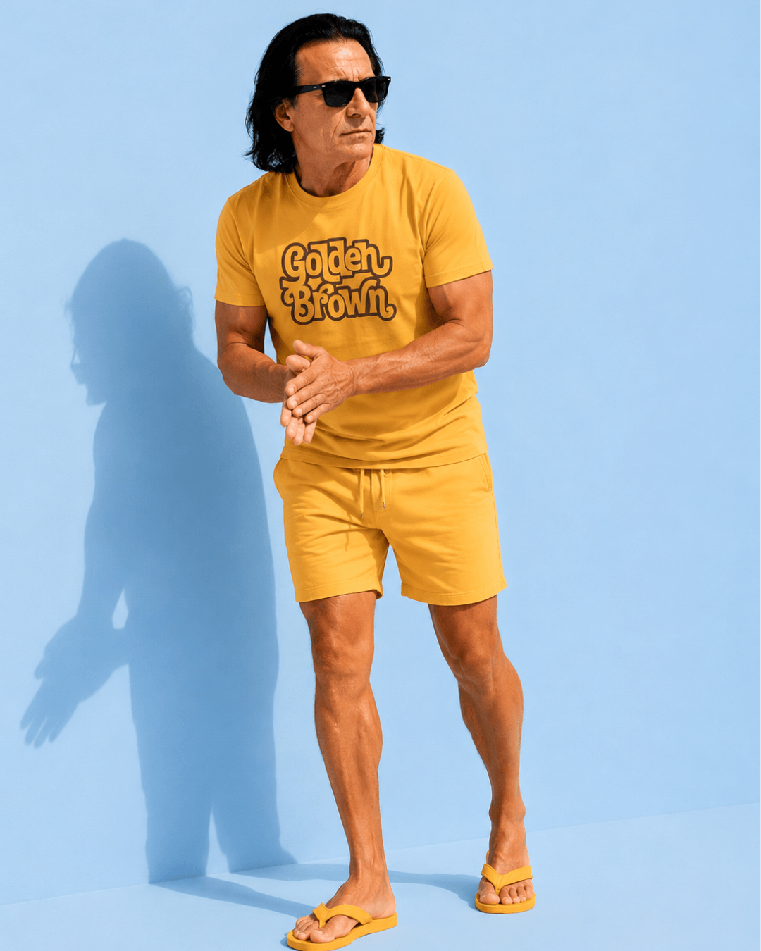 Golden Brown T-shirt | The Ultimate Golden Hour worn by a man in casual summer attire against a blue backdrop.