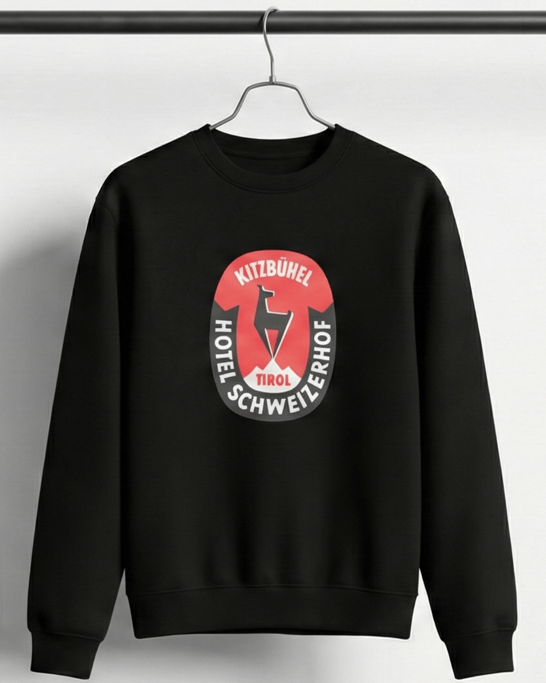 HOTEL KITZBÜHEL HEAVY SWEATER featuring vintage hotel crest on a black background.