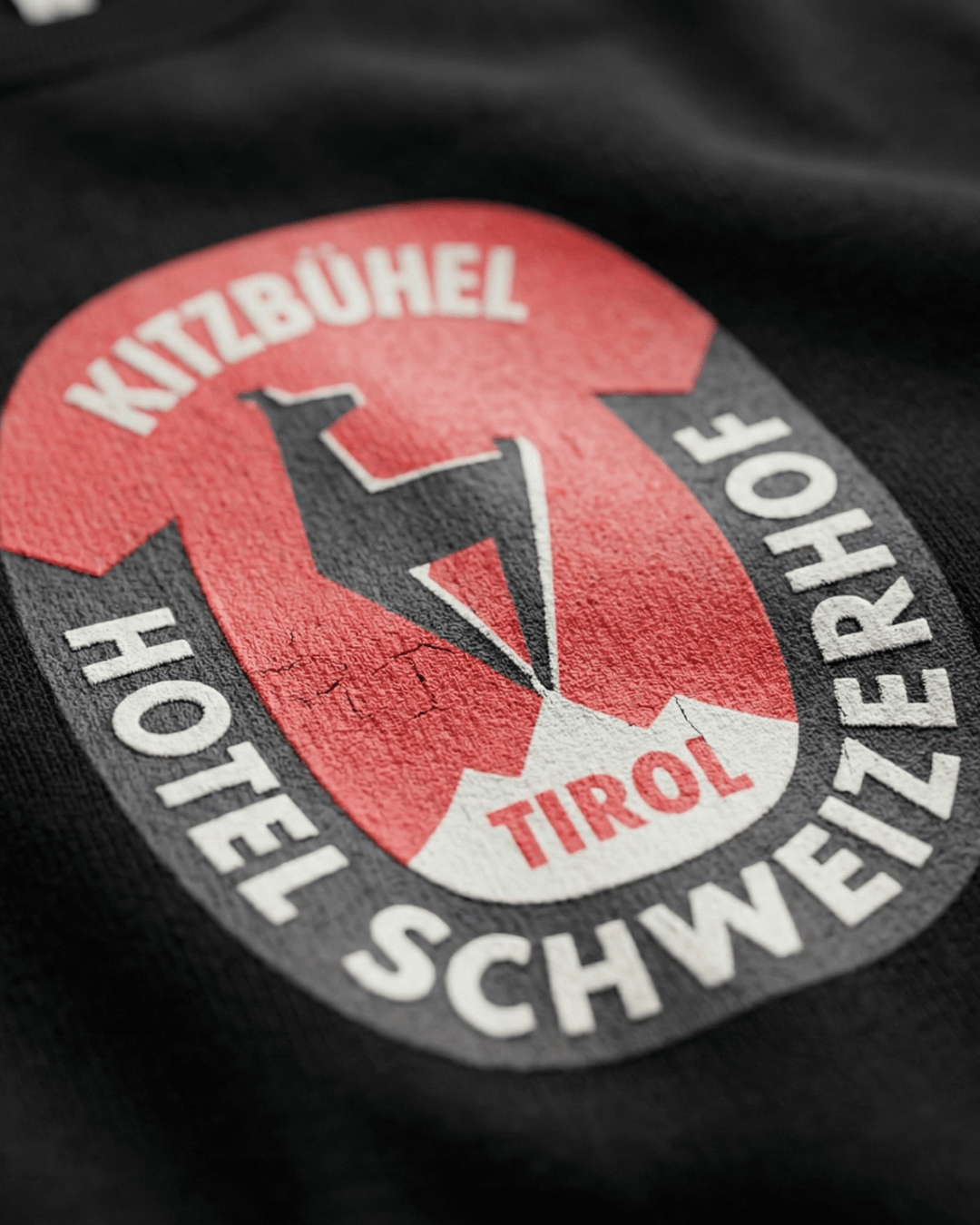 Close-up of the vintage logo on the HOTEL KITZBÜHEL HEAVY SWEATER featuring Kitzbühel Hotel Schweiz erhof design.