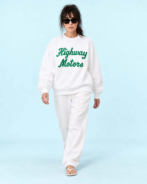 Helga wearing the white BINKY Highway Motors Heavy Sweater with green script graphic