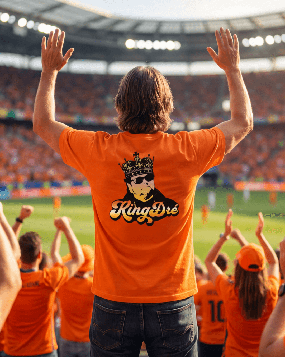 Man wearing King Dre T-Shirt | Koning van het Levenslied, cheering in a lively stadium.