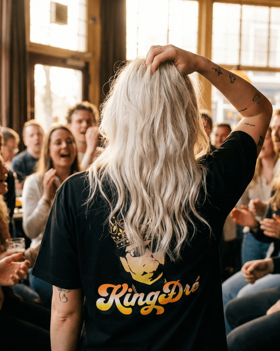 King Dre T-Shirt | Koning van het Levenslied worn by a person in a lively crowd, showcasing the cultural heritage of music.