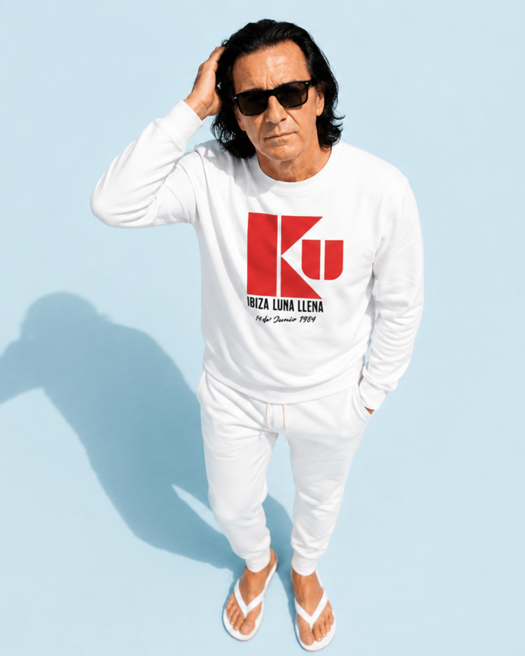 Man wearing Ku Ibiza Sweater | 1984 Club Legend, showcasing a stylish look with sunglasses and white attire.