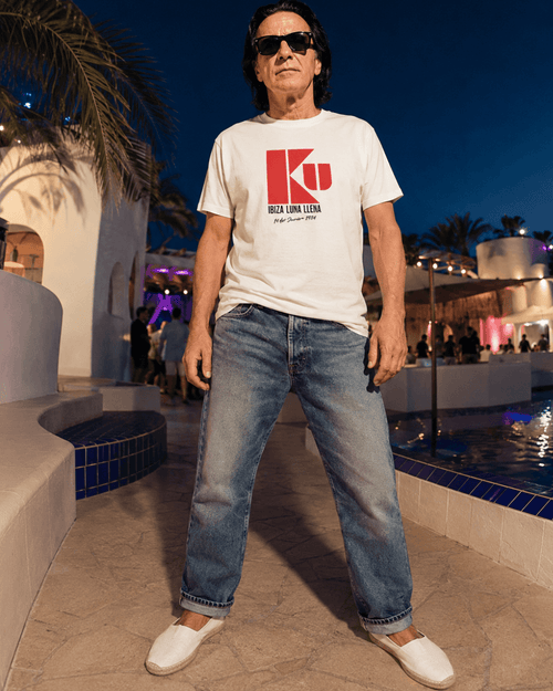 Ku Ibiza T-Shirt | 1984 Club Legend worn by a model outdoors at night with a pool backdrop.