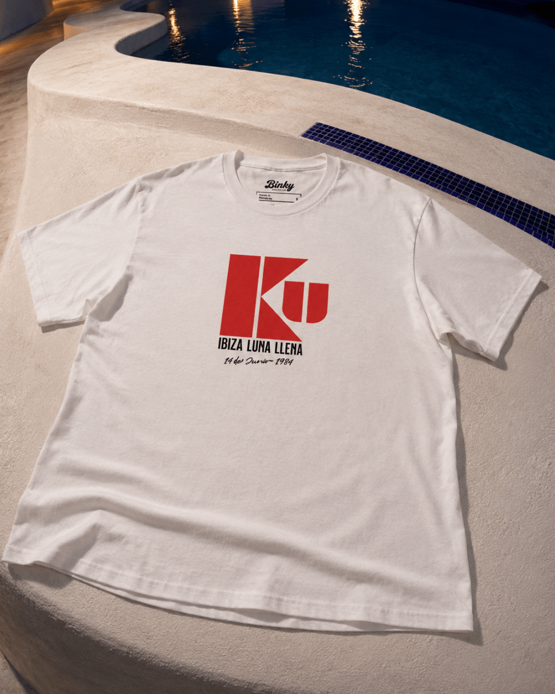 Ku Ibiza T-Shirt | 1984 Club Legend displayed by a pool, featuring a bold retro graphic from Binky comfywear.