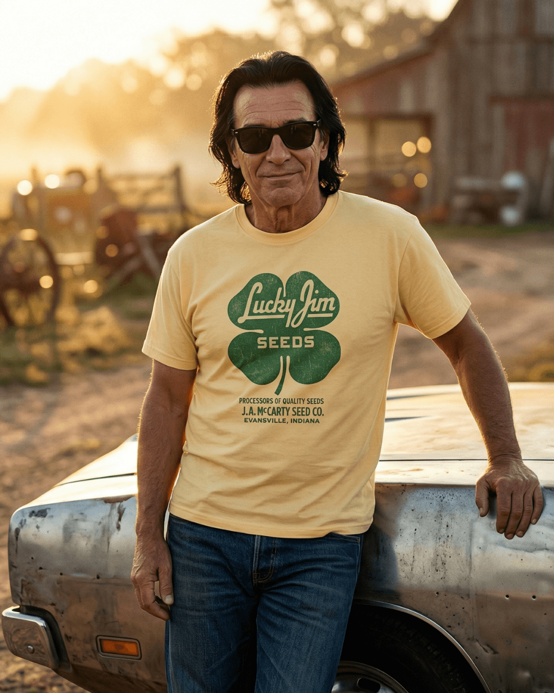 Man wearing LUCKY JIM SEEDS T-SHIRT | HERITAGE WORKWEAR, standing outdoors near a car.