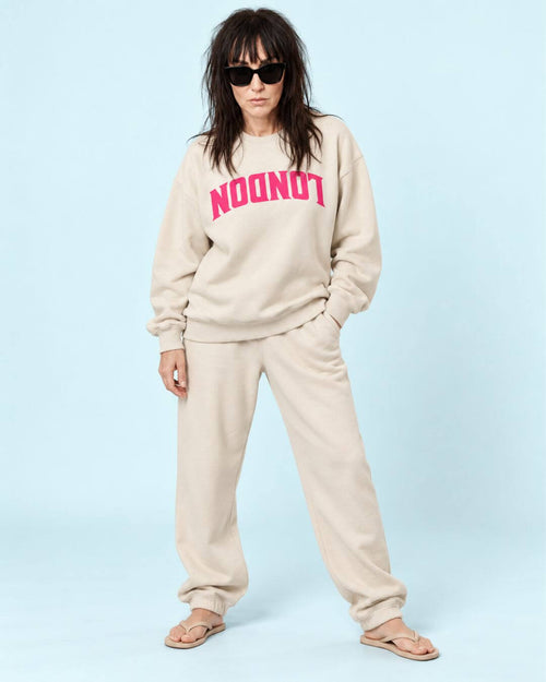 Helga wearing the BINKY COMFYWEAR London Heavy Sweater in Dust with hot pink inverted LONDON graphic.