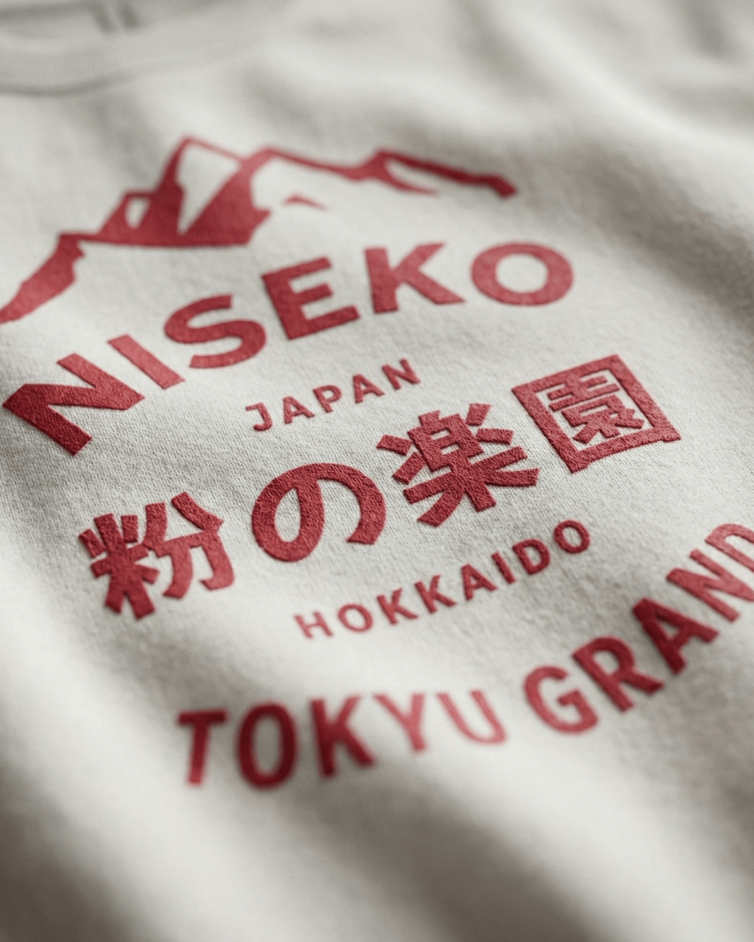 Close-up of the NISEKO POWDER PARADISE HEAVY SWEATER showcasing mountain graphics and bold text.