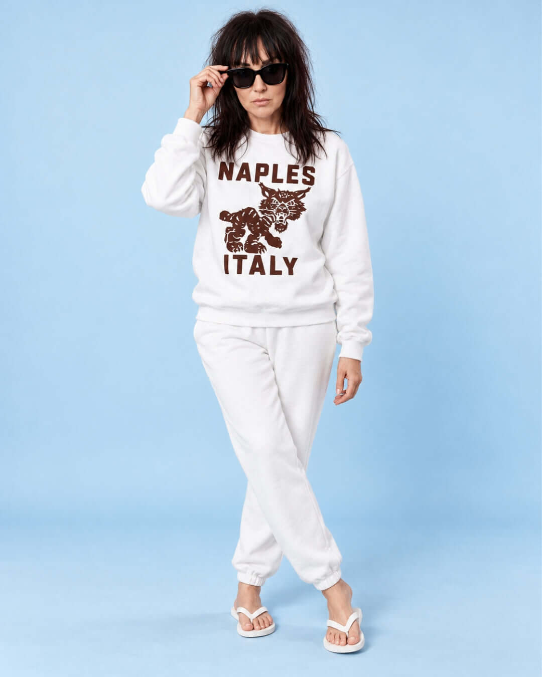 Helga wearing the White Naples Wildcat Soft Sweater with chocolate brown graphic and white joggers