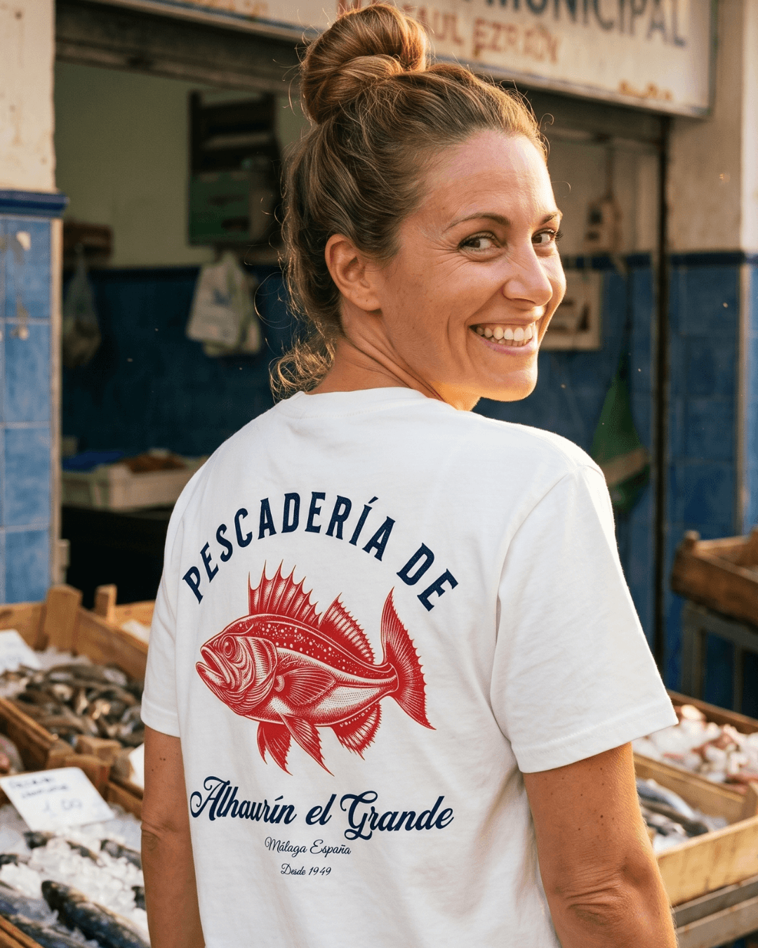 PESCADERIA T-SHIRT | ALHAURÍN EL GRANDE featuring a woman smiling, showcasing the shirt design in a fish market.