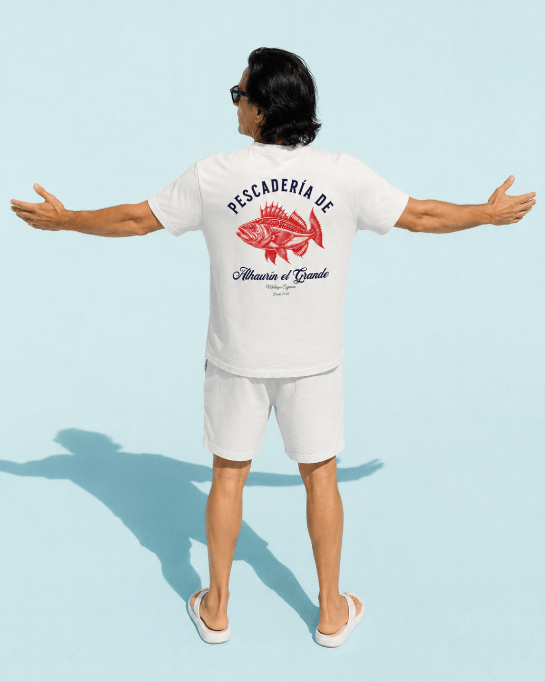 Pescaderia T-Shirt | Alhaurín El Grande worn by a man with arms outstretched, showcasing the vibrant design.