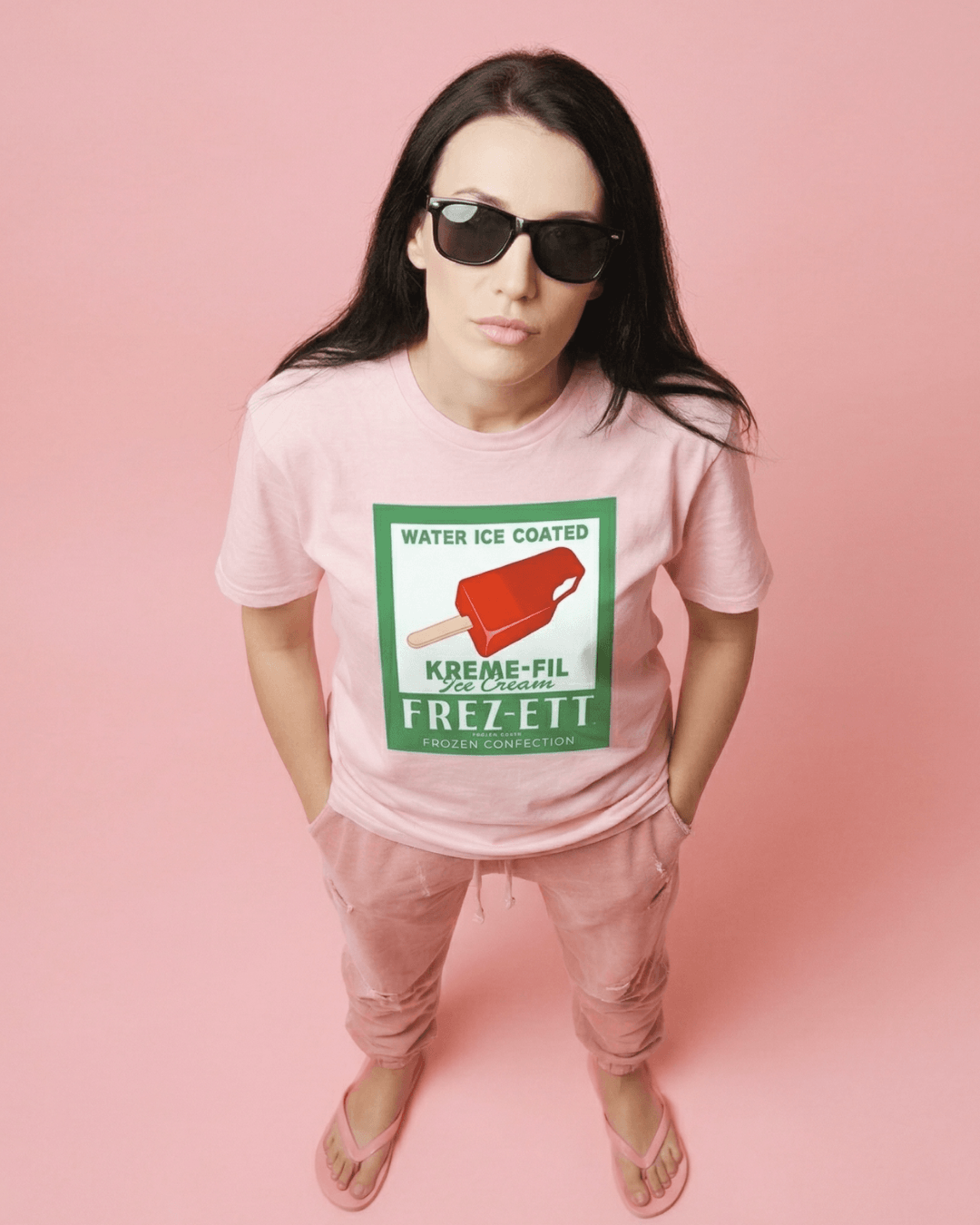 Model wearing pink POPSICLE T-SHIRT | VINTAGE AMERICANA POP-ART with retro ice cream graphic on pastel background.