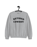 Retired Cowboy Sweater hanging on a hanger, showcasing its relaxed style and cozy fabric.