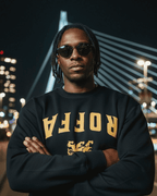 Man wearing ROFFA EST 1340 SWEATER with Rotterdam bridge in background, showcasing city pride.