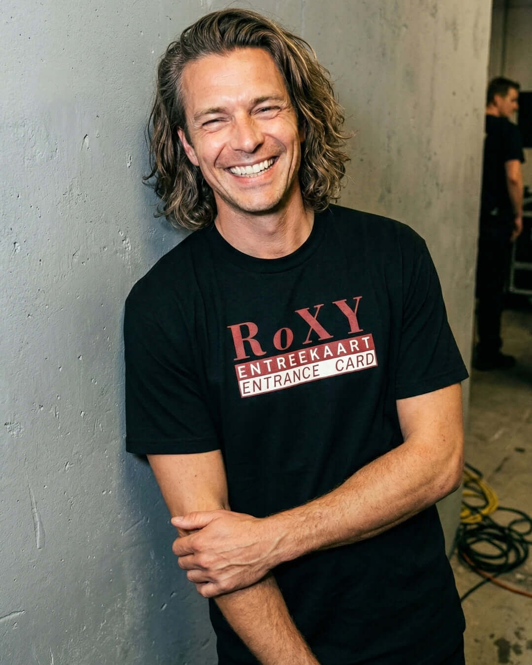 ROXY NIGHTCLUB T-SHIRT | AMSTERDAM HOUSE LEGEND worn by a smiling male model, showcasing the iconic design.