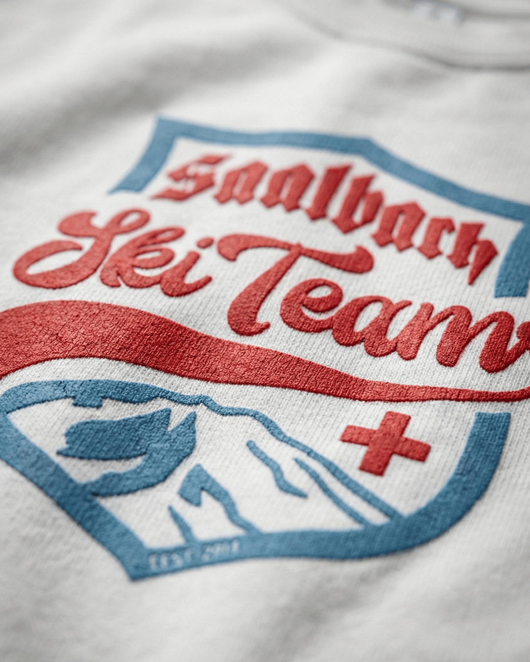 Close-up of the vintage design on the Saalbach Ski Team Heavy Sweater, showcasing the logo and alpine theme.