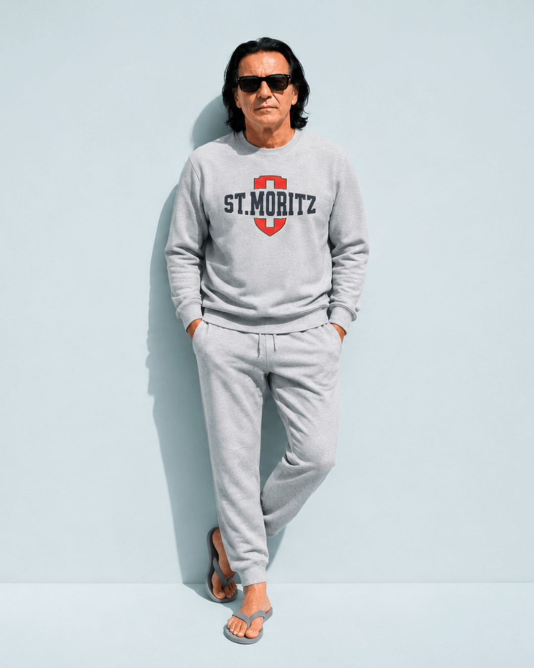Man wearing St. Moritz Heavy Sweater and pants, showcasing Alpine luxury style with Swiss shield and collegiate typography.