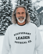 Man wearing a STUYVESANT LEADER HEAVY SWEATER in snow-filled landscape with evergreen trees.