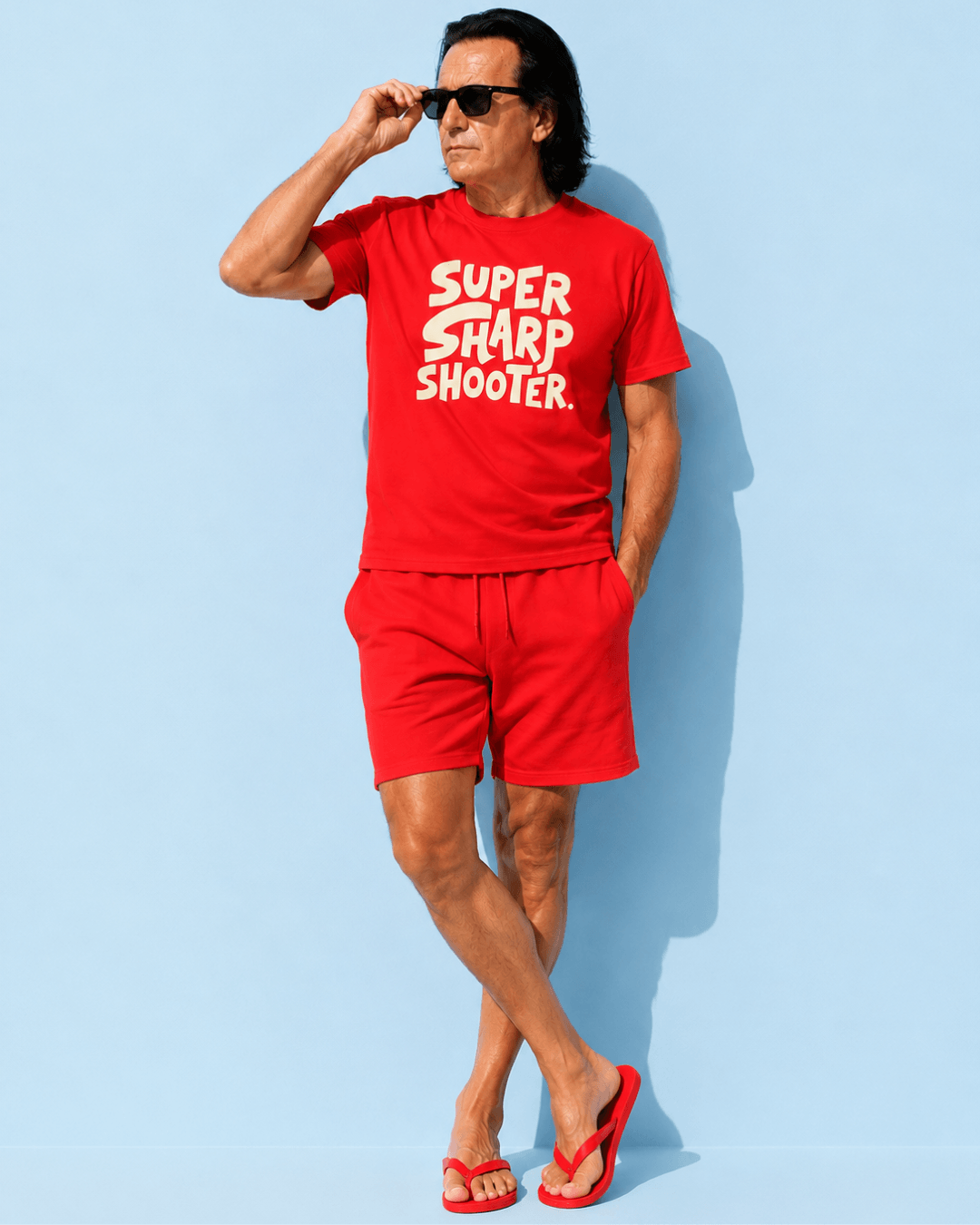 Man in red Super Sharp Shooter T-shirt and shorts, showcasing style and confidence. Always Hit The Mark.
