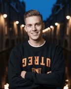 Model wearing UTREG EST 1122 SWEATER against a Utrecht city backdrop, showcasing Dutch heritage and comfywear style.