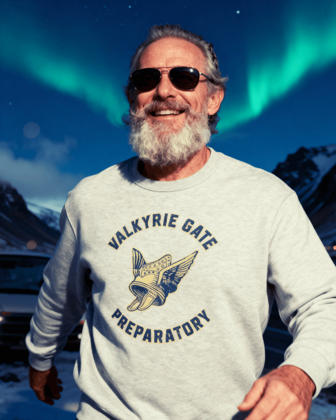 Happy man wearing a VALKYRIE GATE HEAVY SWEATER with winged helmet emblem under aurora lights.
